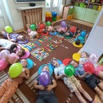 dzieci leżą na dywanie i trzymają balony.jpg