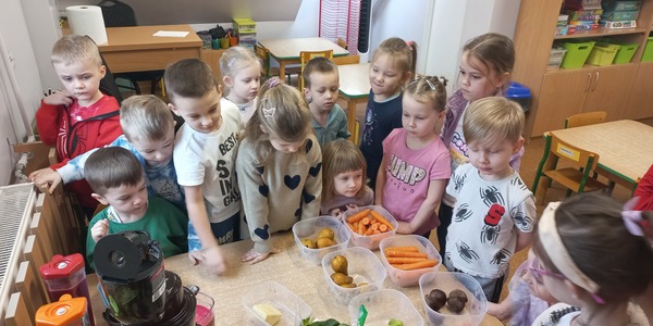 Dzieci obserwują pracę wyciskarki.jpg